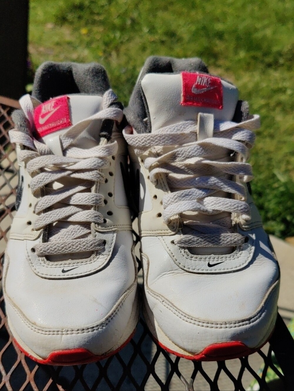 Nike Air Max Navigate White Sneakers with Red Tongue and Sole Accents.